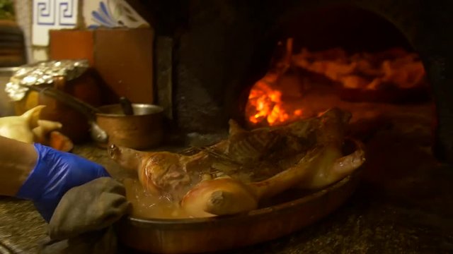 Spanish suckling pig being cooked in a wood fire oven.