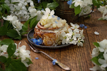 Cinnamon roll with creme cheese and chopped apples jam. Horisontal