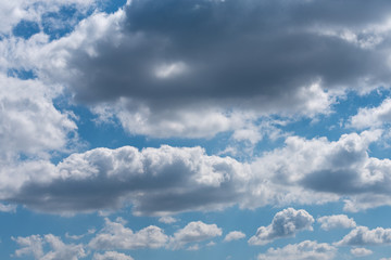 Thick gray clouds in the blue sky on a sunny day. Natural background.