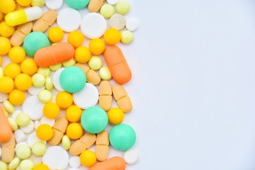 background with white, yellow, orange and green pills on a white background with space for text
