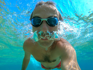 Naklejka premium Swimmer man taking an underwater selfie