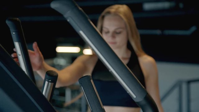 Young woman doing workout on orbitrek in gym