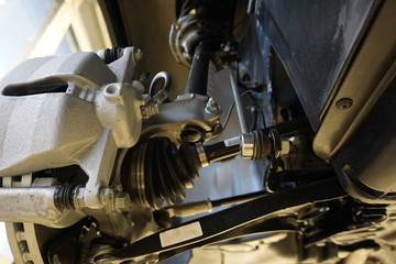 Sharp technical photograph.  The design and elements of a modern car. Front suspension. Shock absorber. Suspension arm of a vehicle. Drive shaft.