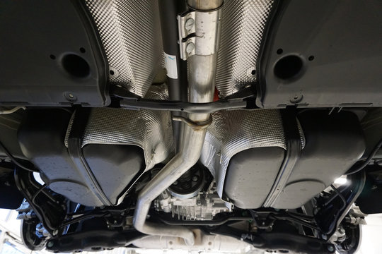 Sharp technical photograph.  The design and elements of a modern car. Details of the exhaust system. Exhaust pipe. Intermediate pipe. Silencer. Sheathing bottom.