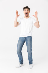 Naklejka premium Excited happy young man posing isolated over white wall background.