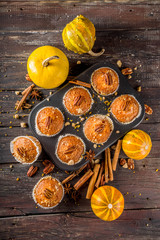 Homemade Autumn Pumpkin Spice Muffins with Pecan nuts. Fall and winter baking. Old rustic wooden background copy space.