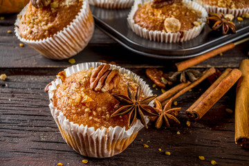 Homemade Autumn Pumpkin Spice Muffins with Pecan nuts. Fall and winter baking. Old rustic wooden background copy space.