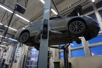 Modern car raised on a lift for repair.