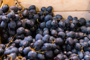 Fresh grapes for sale in a wooden box at fruit market.