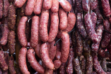 Fototapeta premium Home made smoked sausages for sale at meat market. Traditionally smoked meat on display at the market