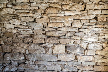 Close up of old flat brown and gray stone wall texture. Layered rocks on a house or building. Architectural stone wall exterior typical in Bulgaria