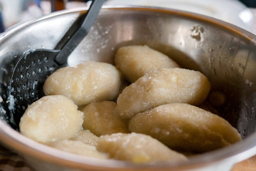 Making of Cepelinai - Zeppelins is national Lithuanian dish. Serving hot zeppelins on a plate at home © CrispyMedia