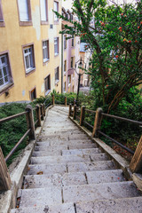 Fototapeta premium Narrow city street with stairs in Budapest. Vertical view of an abandoned step lane in Hungary.