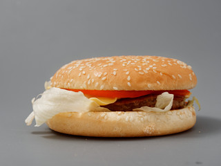 big burger with cutlet cheese tomato cabbage on gray background