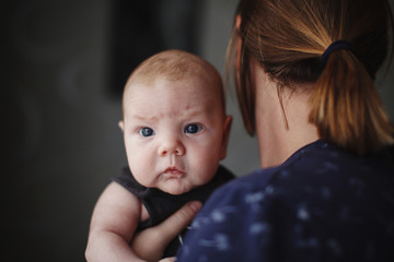 Baby in the arms of the mother.