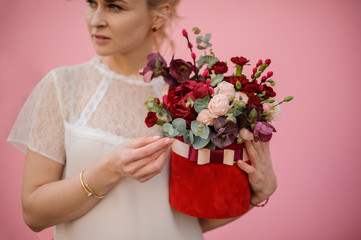 Blond girl hold bouquet in hat box