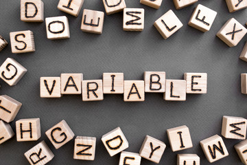 the word variable wooden cubes with burnt letters, variable life, gray background top view,...