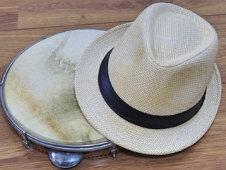 A samba player (sambista) hat and a pandeiro (tambourine), a Brazilian percussion musical instrument. The instrument is widely used to accompany samba and choro, two popular Brazilian rhythms.