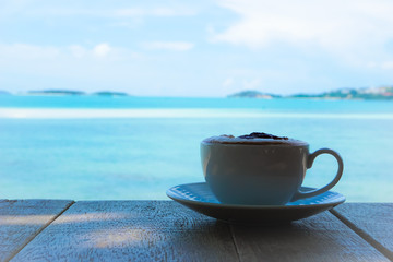 Hot coffee with clear milk bubbles, white cups and sea views.