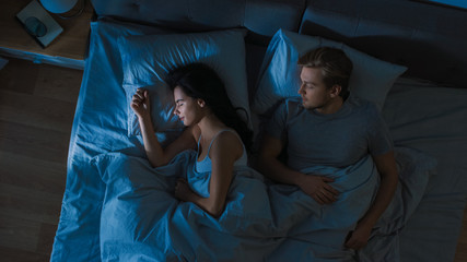 Top View Bed at Night: Attractive young Couple Sleeping Together. Blue Nightly Colors with Cold...