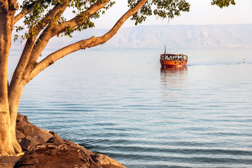 Evening walk on the boat on the Sea of Galilee. - obrazy, fototapety, plakaty