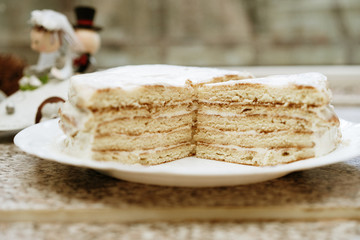 homemade honey cake in the cut. bride and groom in the background. selective focus