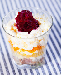 verrin with salad herring under fur coat from vegetables on striped tablecloth