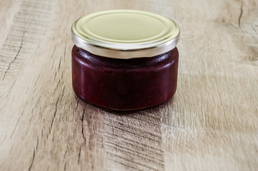 strawberry jam in a can on a wooden background. Close-up.