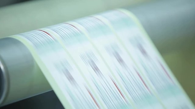 Metal White Label Printing Rolls with High speed labeling machine in industrial factory, sticker on product in manufacture. Flexible packaging. Low angle.