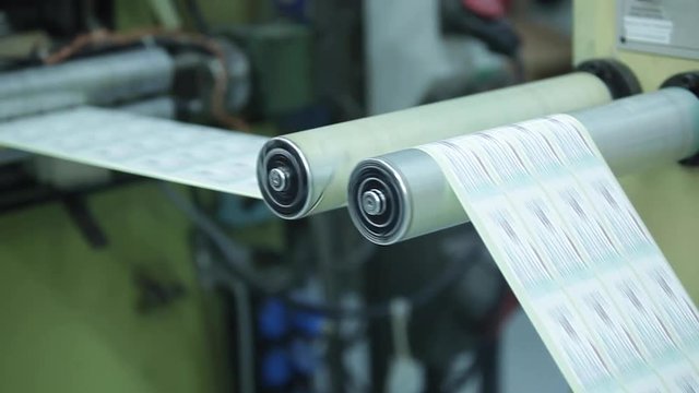 Metal White Label Printing Rolls with High speed labeling machine in industrial factory, sticker on product in manufacture. Flexible packaging. Tilt Up.