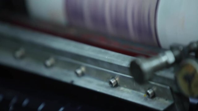 Metal Purple Label Printing Rolls with High speed labeling machine in industrial factory, sticker on product in manufacture. Flexible packaging. Close Up Macro.