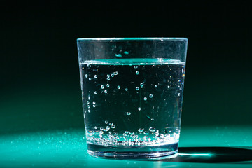 glass of water on a table  on a dark background