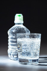 Served table set of mineral water bottle and glass