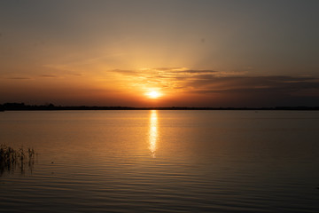 Fototapeta na wymiar Sunset on the lake, reflection in the water, sun path,