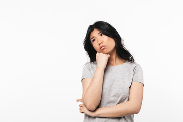 Obraz premium Asian thinking beautiful young woman posing isolated over white wall background.