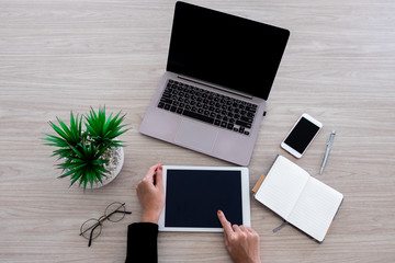 Top view image of business woman point at the tablet screen  on the wooden desk with other office...