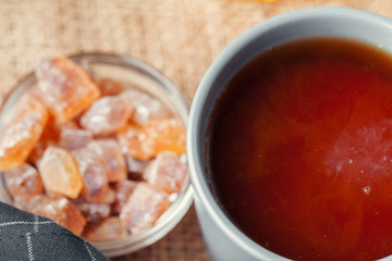 Close up of a cup of tea and  candies on wooden table