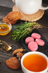 glass teapot with cup of black tea on wooden table