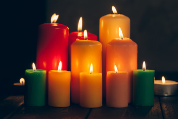 candles burning in darkness over black background. commemoration concept.