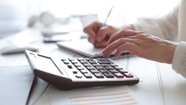  The Hands Of An Accountant Work On A Calculator And Prepare A Financial Report.