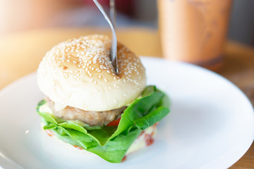Hamburger in a white ceramic dish at restaurant