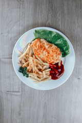 chicken chop and fried potatoes on white plate