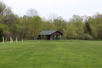Obraz premium The old wood picnic shelter in the park on a cloudy day.