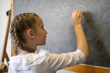 Elementary student drawing on blackboard