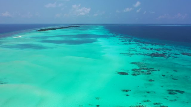 crystal clear waters with corals on seafloor and distant tropical island, biodiversity concept, Thailand,Aerial drone shot