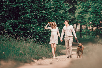 young family and their pet walking along the path in the Park