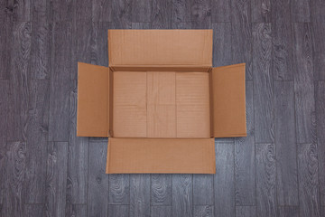 Flat lay of empty open cardboard box on wooden surface