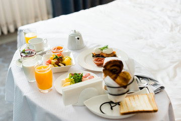 selective focus of tasty breakfast near cup of coffee and glasses with orange juice on table