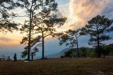 Tourists stand to watch the sunset at Pha Mak Duk Phu Kradueng on January 11,2019 in Loei, Thailand