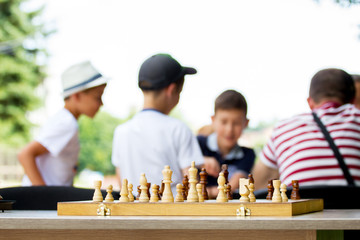 A board with chess pieces on the background of children playing chess_